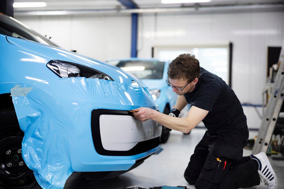 man-wrapping-car-with-blue-cover-full-shot_23-2149385685 man-wrapping-car-with-blue-cover-full